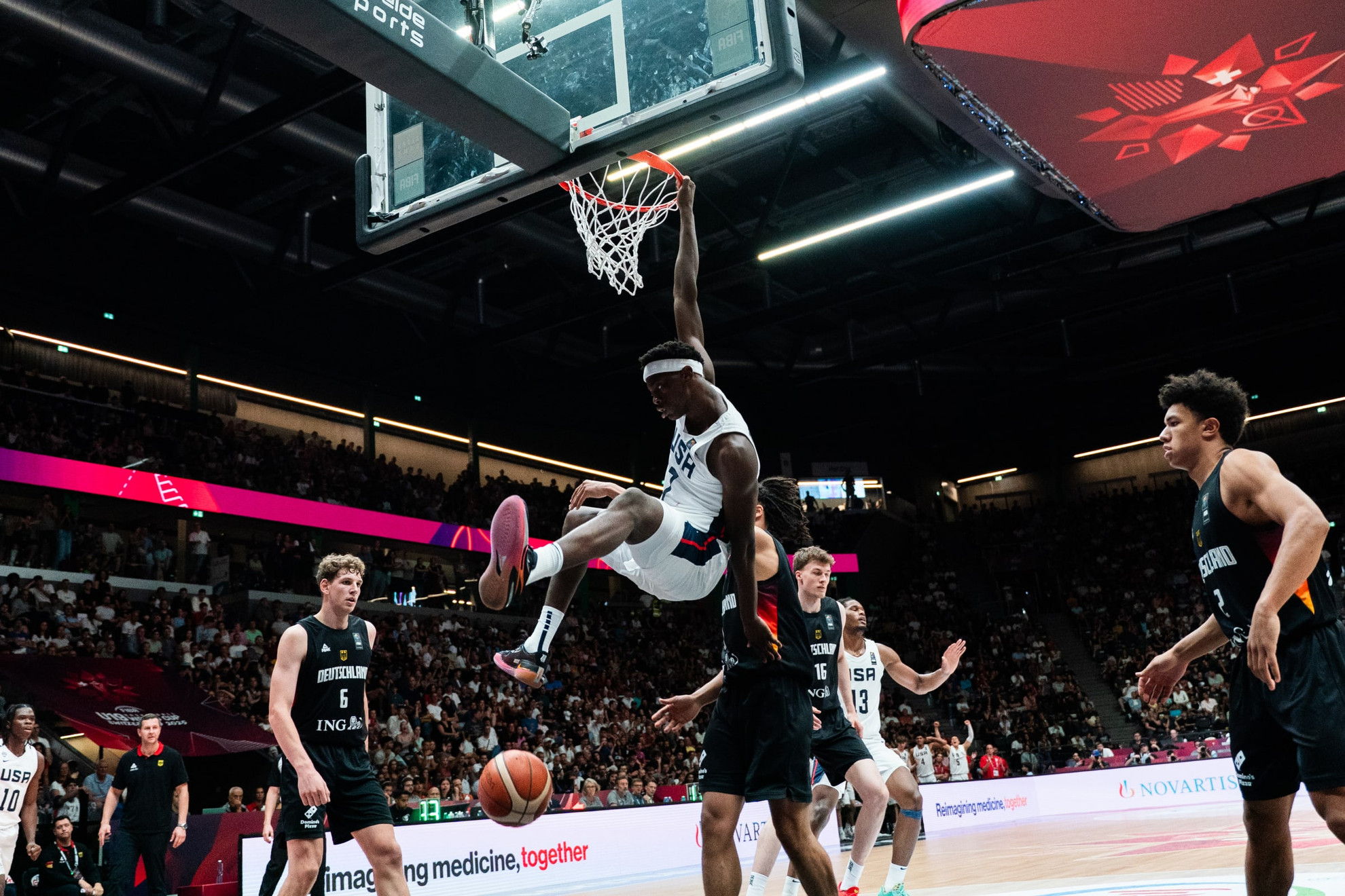 AJ Dybantsa berseragam putih Amerika Serikat menggantung di ring setelah dunk melawan Jerman di final FIBA U19 World Cup 2025 di Lausanne